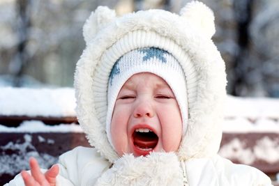 Close-up of baby boy crying while wearing warm clothing