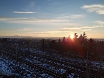 Railroad tracks against sky during sunset