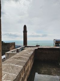 Built structure by sea against sky