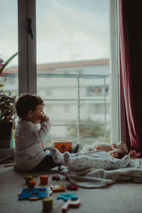 Baby siblings sitting at home