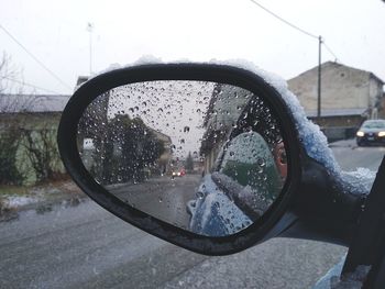 Water drops on side-view mirror of car