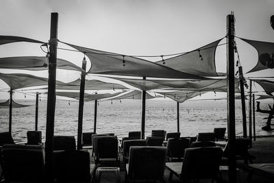 Chairs on beach against clear sky