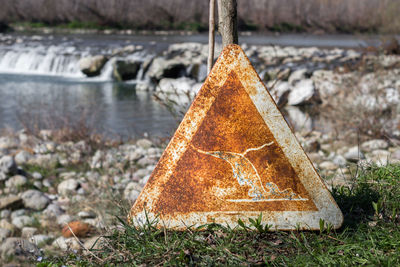 Abandoned information sign against river