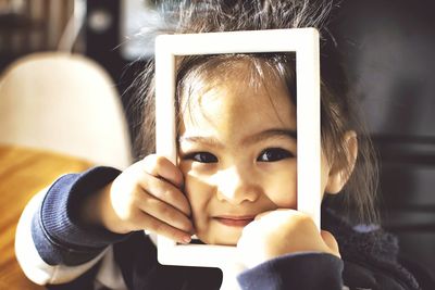 Portrait of smiling girl with photo frame