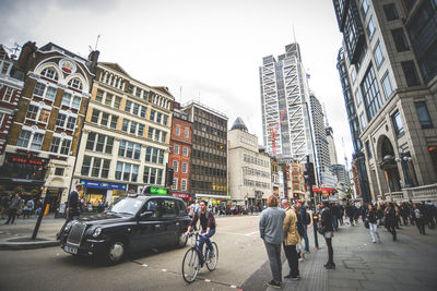 People on city street against buildings