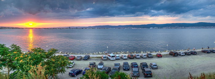 High angle view of people at beach against sky during sunset