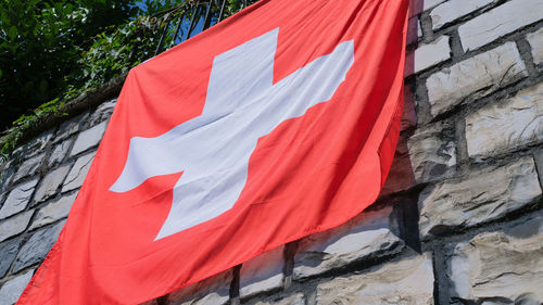 Low angle view of flag against red wall