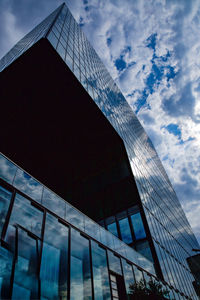 Low angle view of glass building against sky