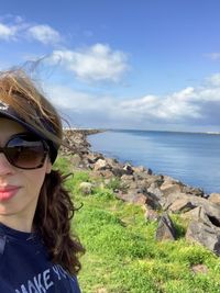 Portrait of woman wearing sunglasses against sky