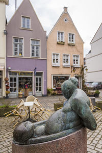 Statue outside house against buildings