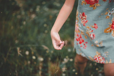 Midsection of woman walking on field