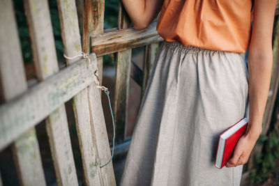 Front view of person holding red book in hand