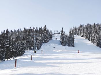 Ski lift against sky during winter