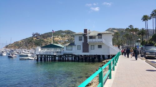 Buildings by sea against blue sky