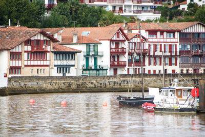 Boats moored on river by buildings in city