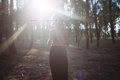 People standing in forest on sunny day