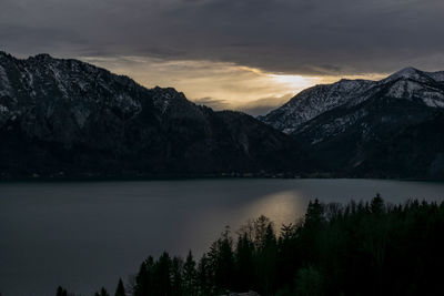 Scenic view of lake and mountains against sky during sunset