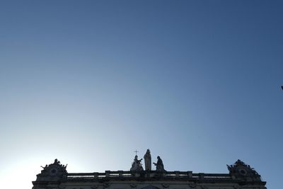 Low angle view of statue against clear blue sky