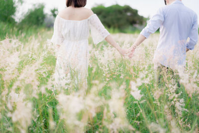 Rear view of couple standing on field