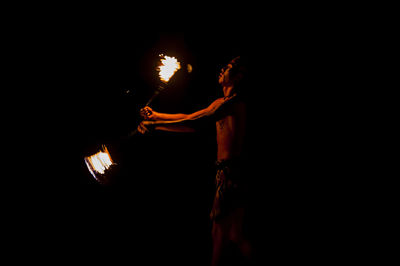 Silhouette of woman standing against dark background