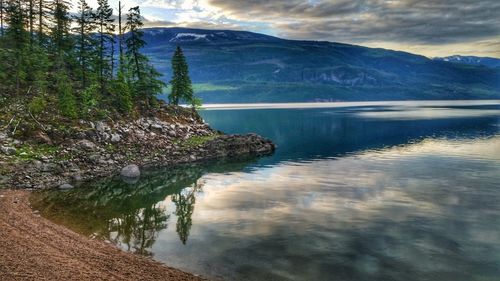 Scenic view of lake by mountain against sky