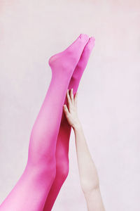 Low section of woman with pink legs against white background