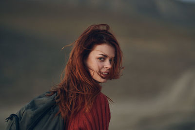 Portrait of smiling young woman against blurred background