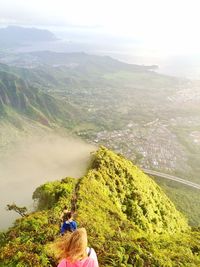 Rear view of people on mountain against sky