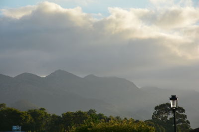 Scenic view of mountains against cloudy sky