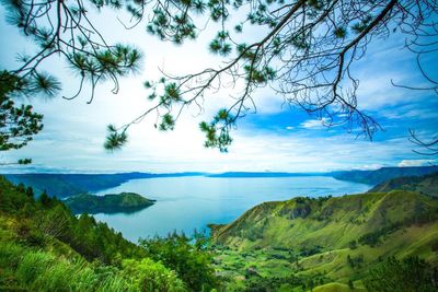 Scenic view of sea and mountains against blue sky