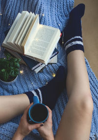 Low section of woman reading book