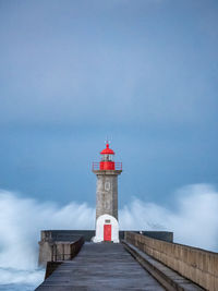 Lighthouse by sea against sky