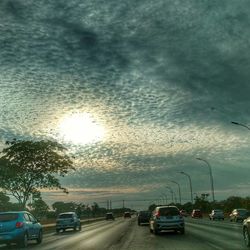 Cars on road in city against sky