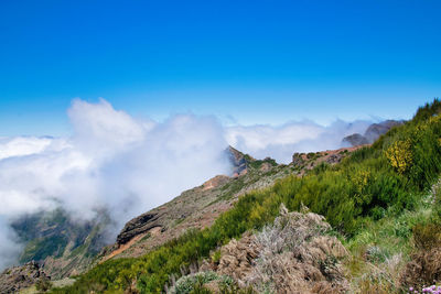 Scenic view of mountains against blue sky