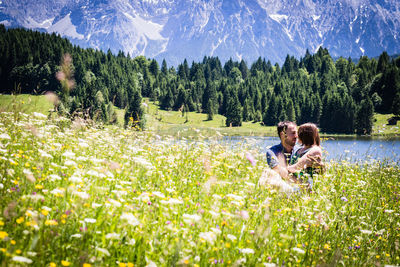 Couple romancing while sitting on grassy land