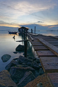 Pier over sea against sky during sunset