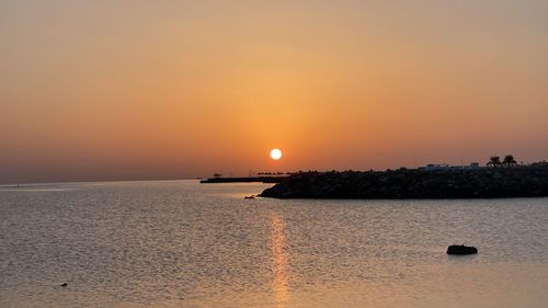 Scenic view of sea against orange sky