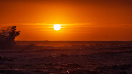 Scenic view of sea against romantic sky at sunset