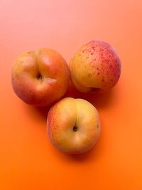 Three ripe apricots, fresh fruit, orange apricots, fresh vitamins, orange background, summer fruits