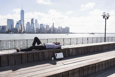 Usa, man resting at new jersey waterfront with view to manhattan