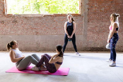 Full length of young woman standing against wall