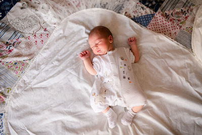 High angle view of baby sleeping on bed