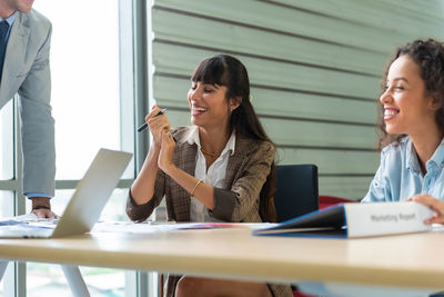 Smiling businesswoman with colleagues in office