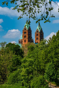 Low angle view of trees and buildings against sky