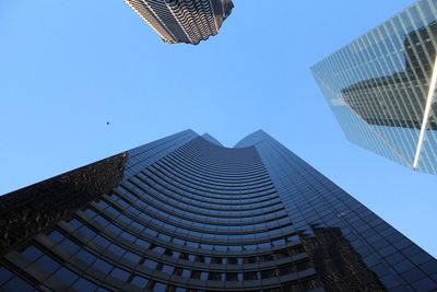 Low angle view of modern buildings against blue sky