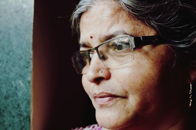 Close-up of thoughtful mature woman looking away by wall