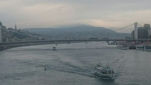 Boats in river with city in background