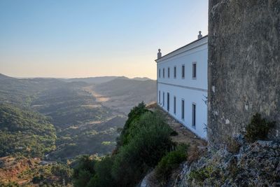 Buildings on mountain against clear sky