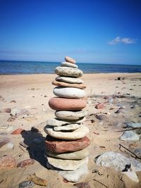 Stack of stones on beach against sky