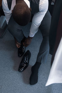 A well dressed businessman tying his shoe laces